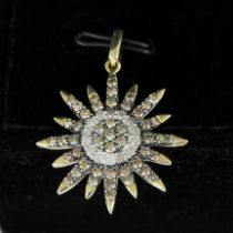 A 10ct yellow gold sunburst pendant set with champagne and white diamonds, L. 3.2cm.