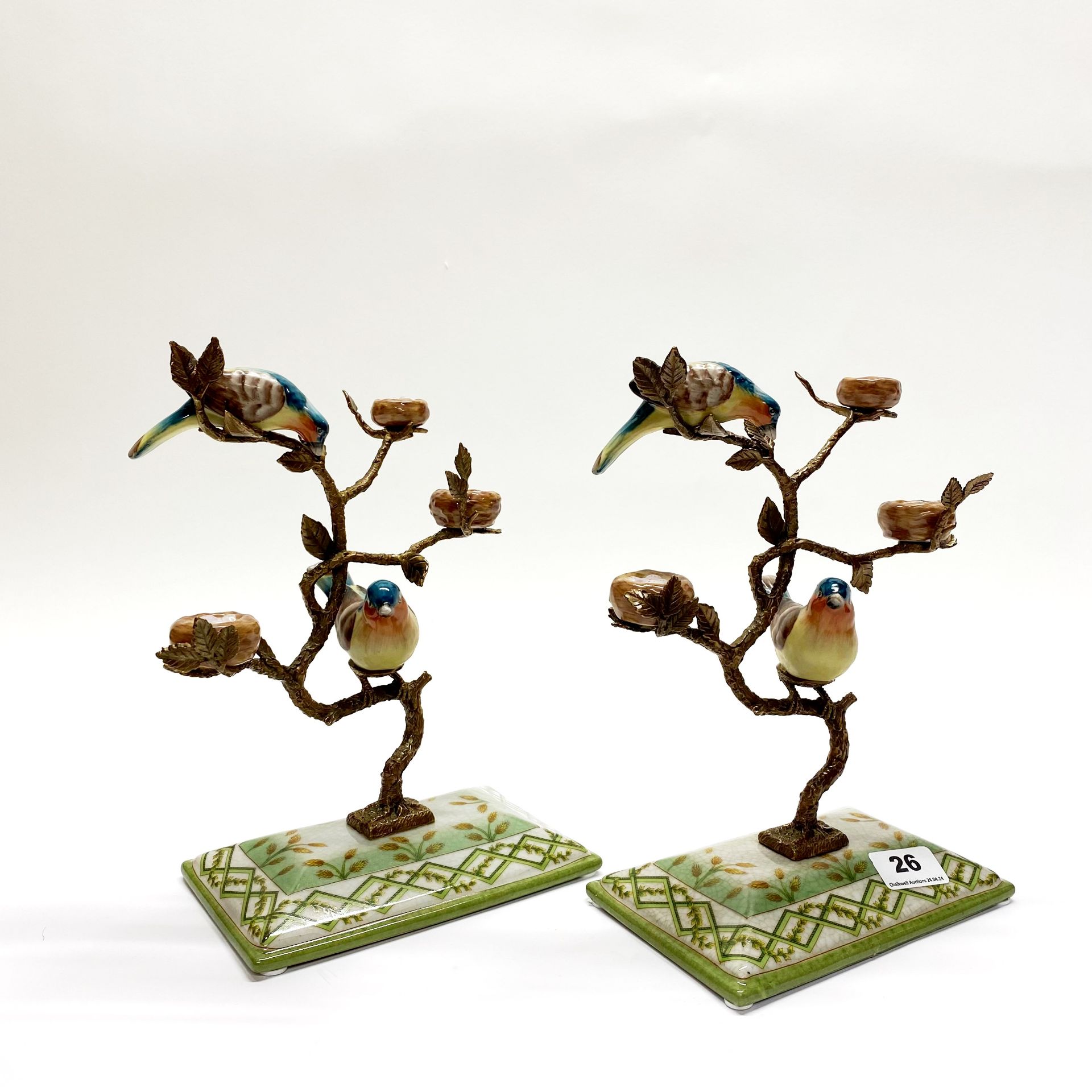 A pair of continental porcelain and ormolu figures of birds on branches. H. 27cm