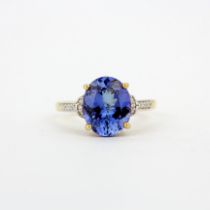 A 14ct yellow gold ring set with a large oval cut tanzanite and diamond set shoulders, (O).