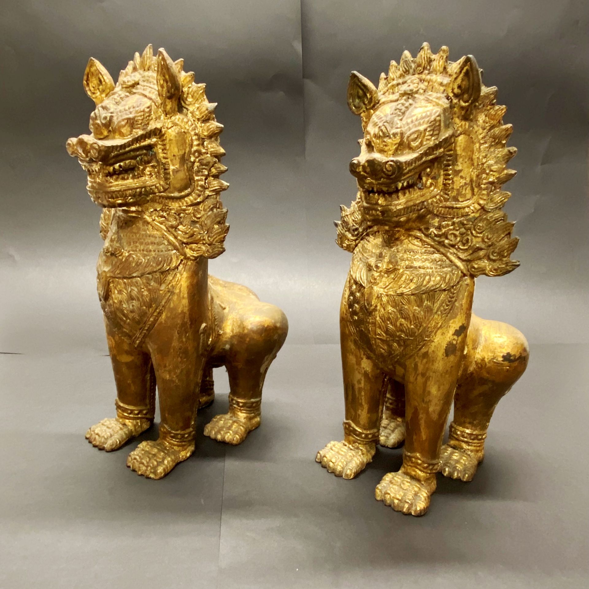 A pair of 19th/20thC Burmese gilt bronze figures of temple lions H. 28cm