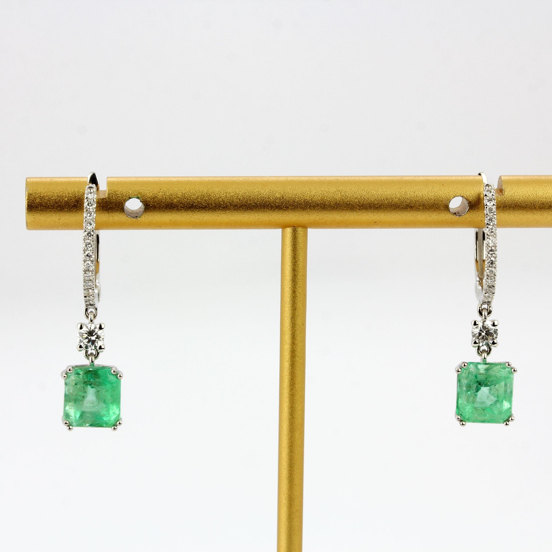 A pair of 18ct white gold drop earrings set with emerald cut emeralds and diamonds, L. 2.7cm.
