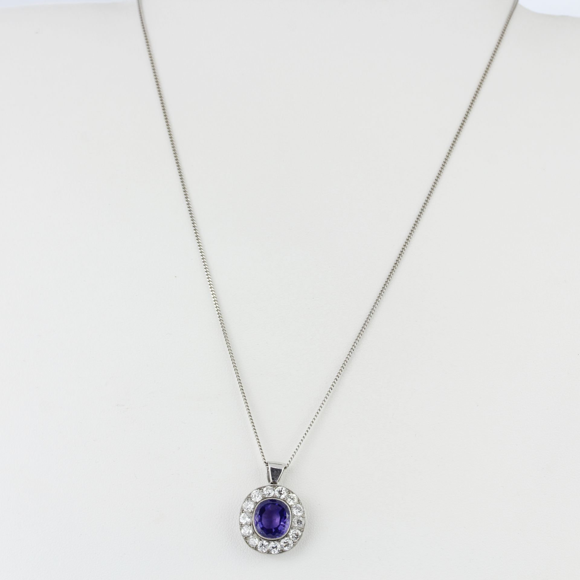 A white metal (tested minimum 9ct gold) pendant set with an oval cut purplish sapphire surrounded by - Image 4 of 4