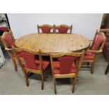 An extending pine oval dining table, L. 153cm, together with six dining chairs.