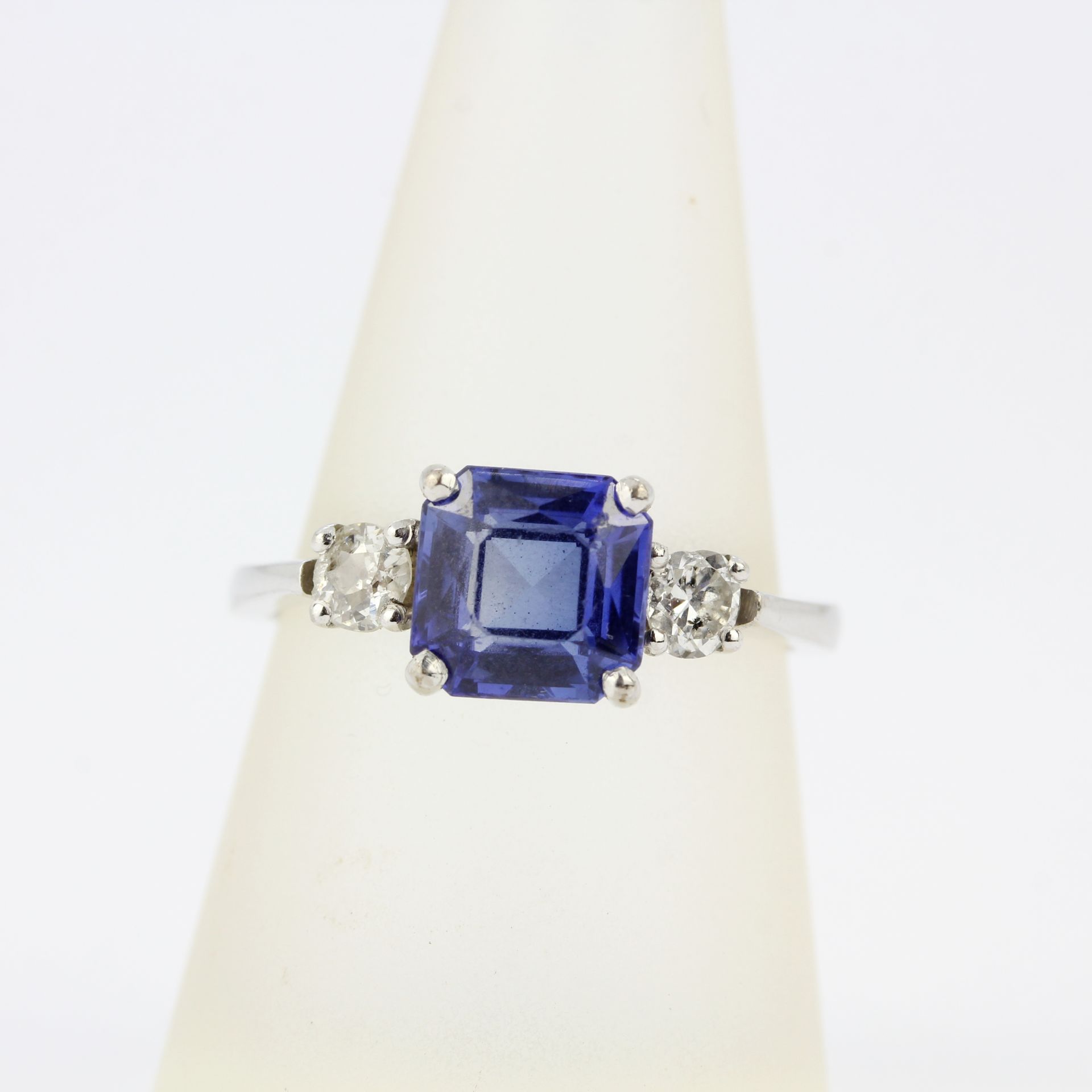 An 18ct white gold ring set with a fancy cut sapphire flanked by brilliant cut diamonds, diamonds