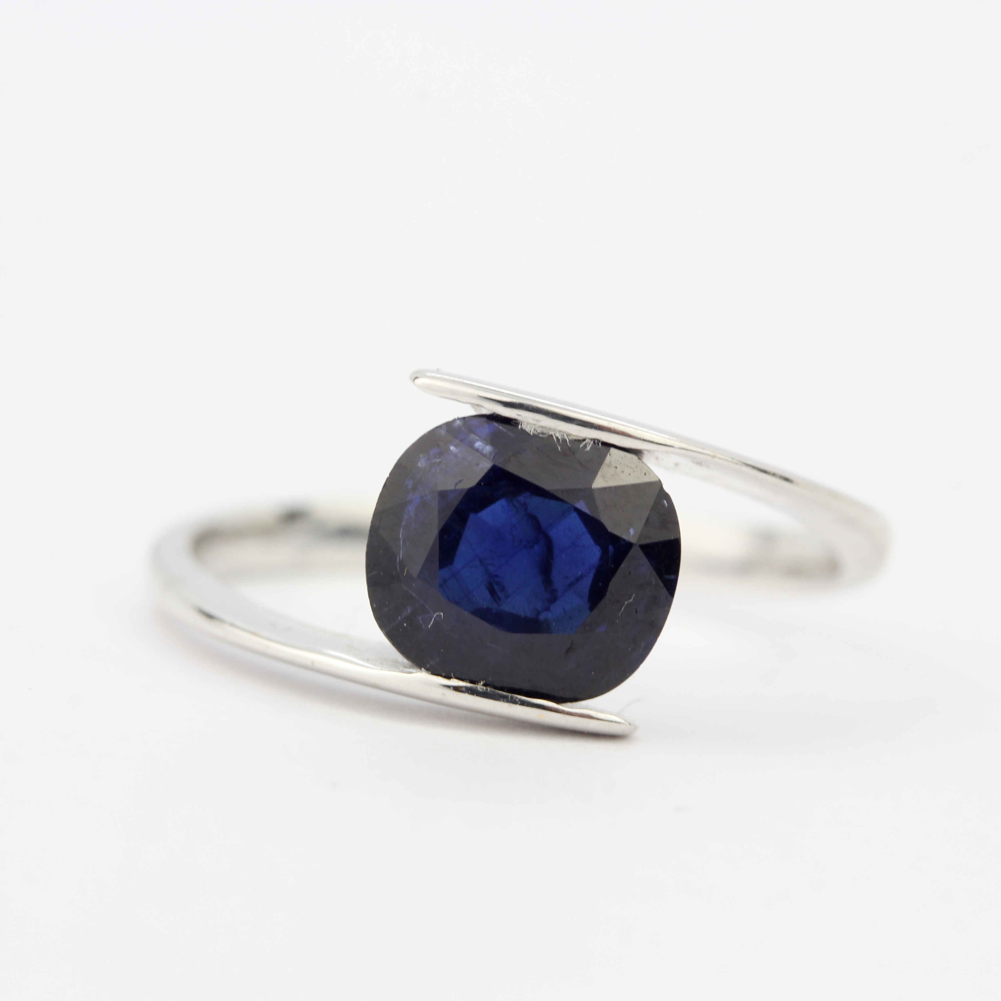 An 18ct white gold (tested) ring set with a 1.9ct cushion cut royal blue sapphire, ring size L.