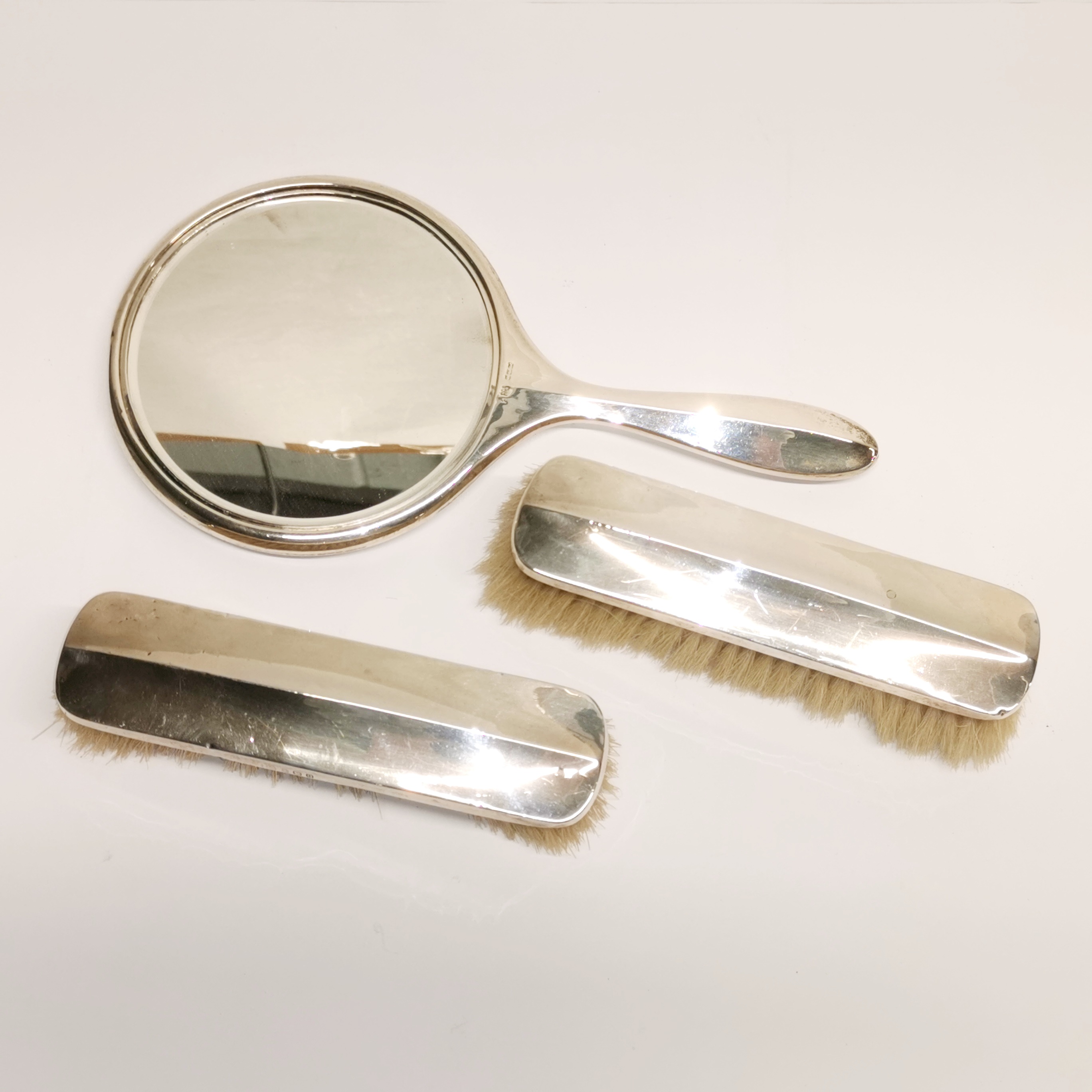 A three piece hallmarked silver dressing table set.