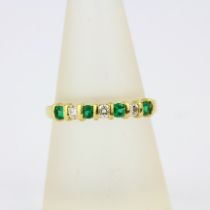 An 18ct yellow gold half eternity ring set with brilliant cut diamonds and emeralds, (O.5).