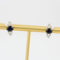 A pair of 14ct white gold earrings set with oval cut sapphires and brilliant cut diamonds, L. 1.