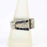 A white metal (tested minimum 9ct gold) ring set with step cut sapphires and old brilliant cut