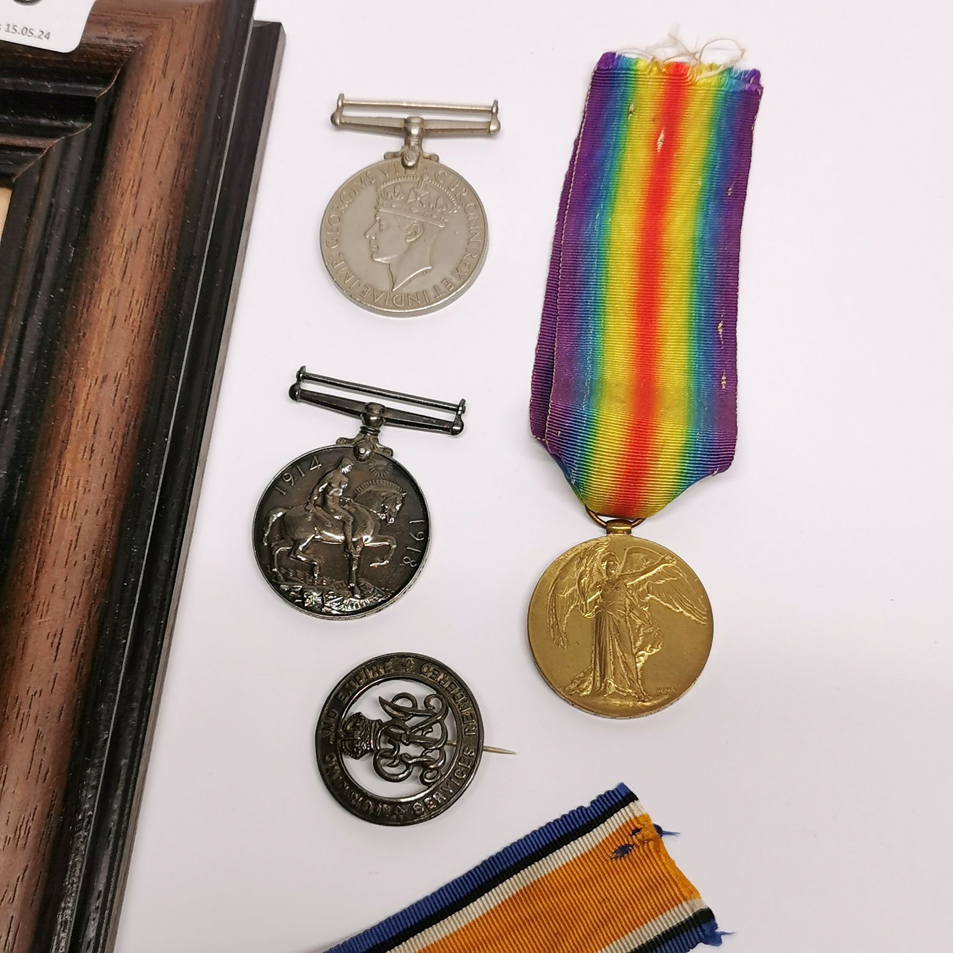 A frame containing two WWII medals with three others and a badge. - Image 2 of 4