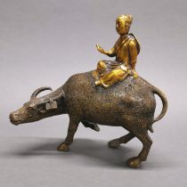 A Chinese gilt bronze figure of a scholar riding a water buffalo, H. 23cm.