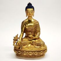 A Tibetan gilt bronze figure of a seated Buddha with temple quality hand painted face, H. 30cm.