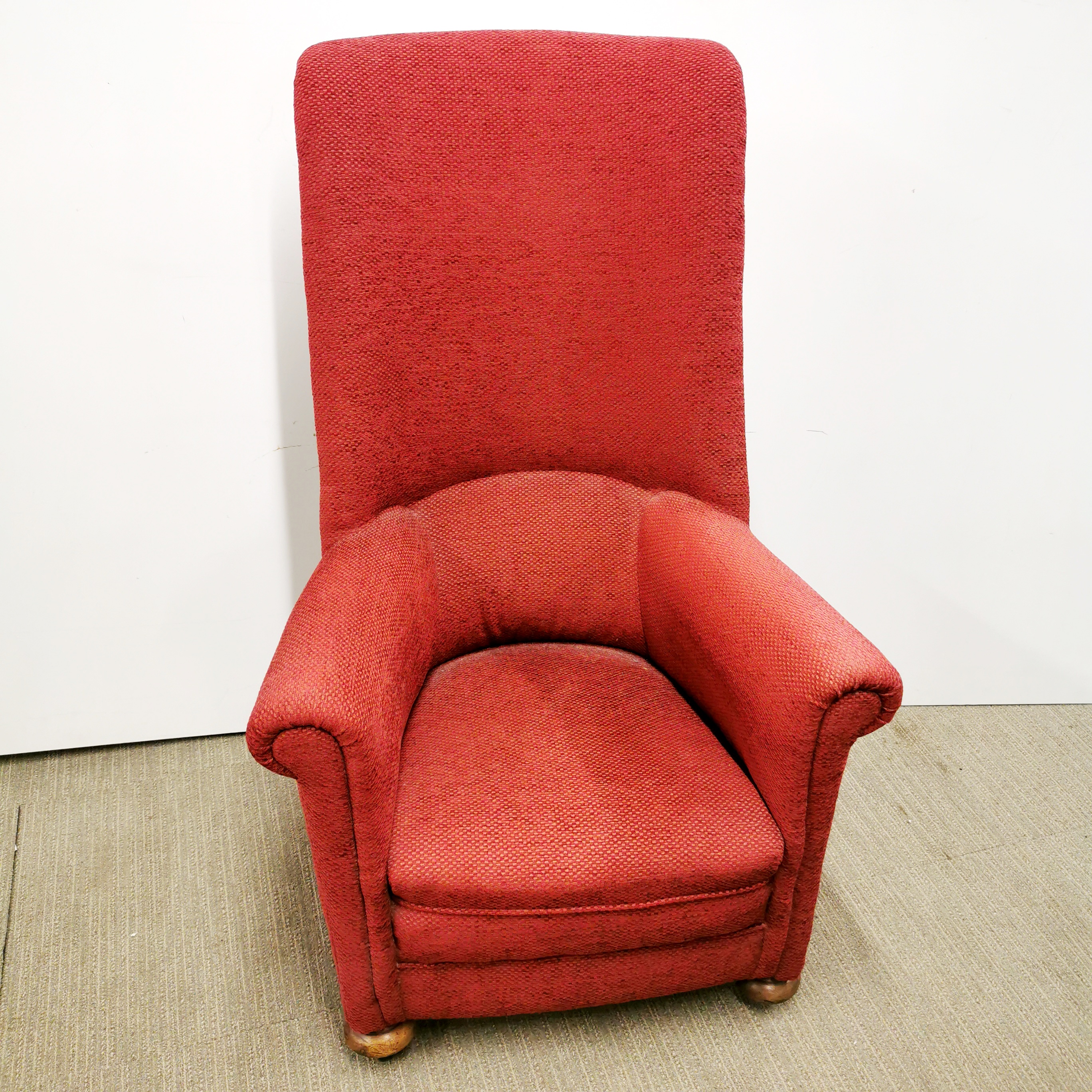A red upholstered high back armchair.