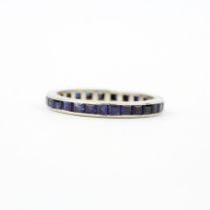 A white metal (tested platinum) step cut sapphire set full eternity, ring size (L.5).