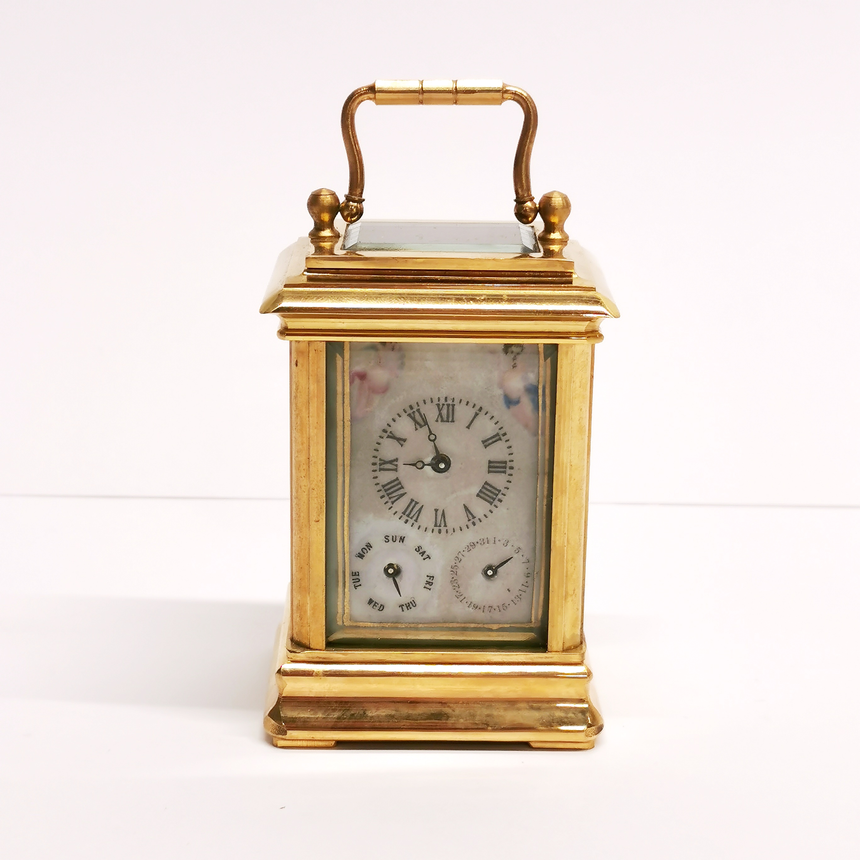 A small gilt brass carriage clock with porcelain panels, H. 10cm.