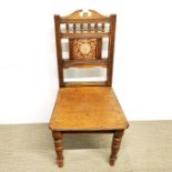 A 19thC tile backed oak hall chair.