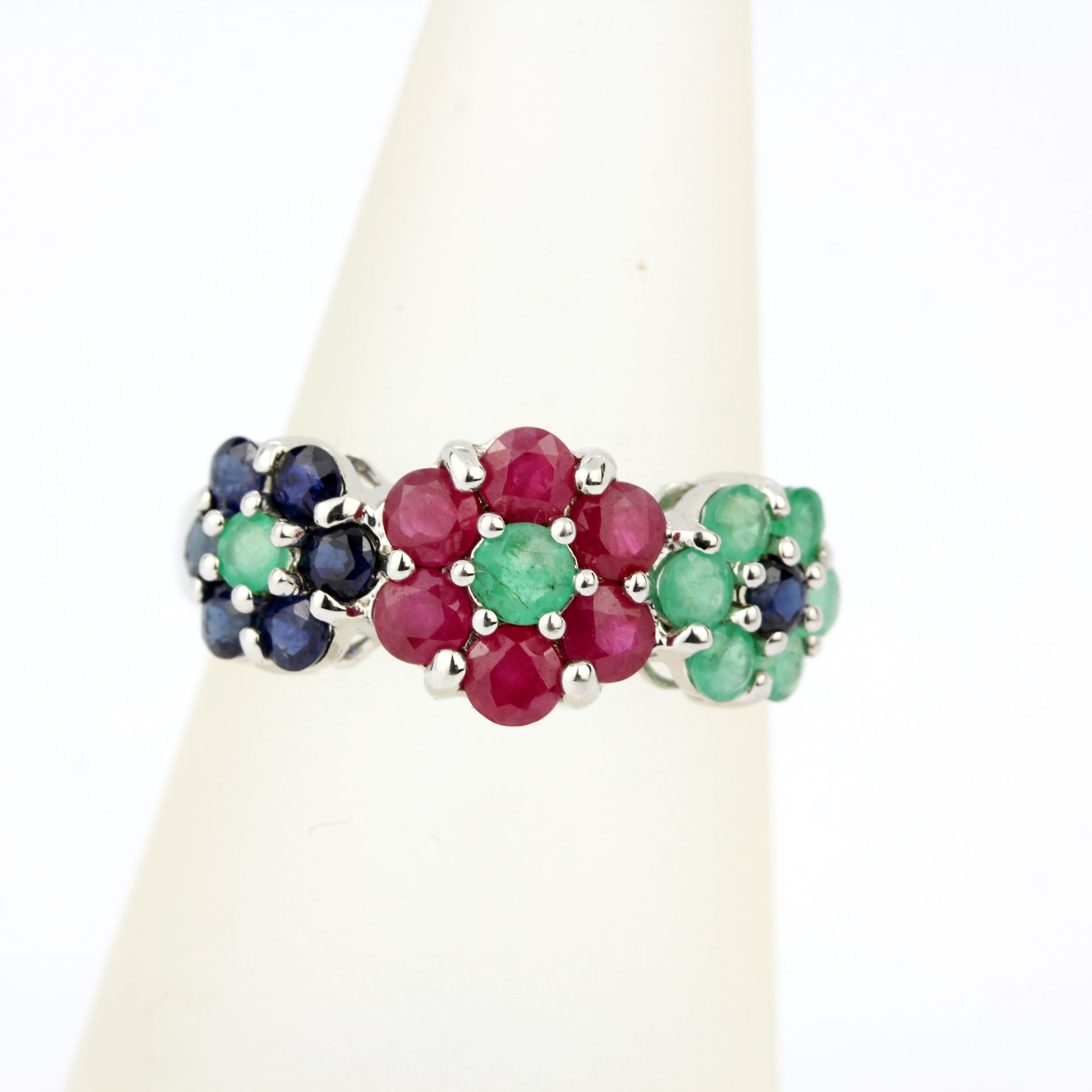 A 9ct white gold flower shaped triple cluster ring set with rubies, emeralds and sapphires, (O). - Image 3 of 3