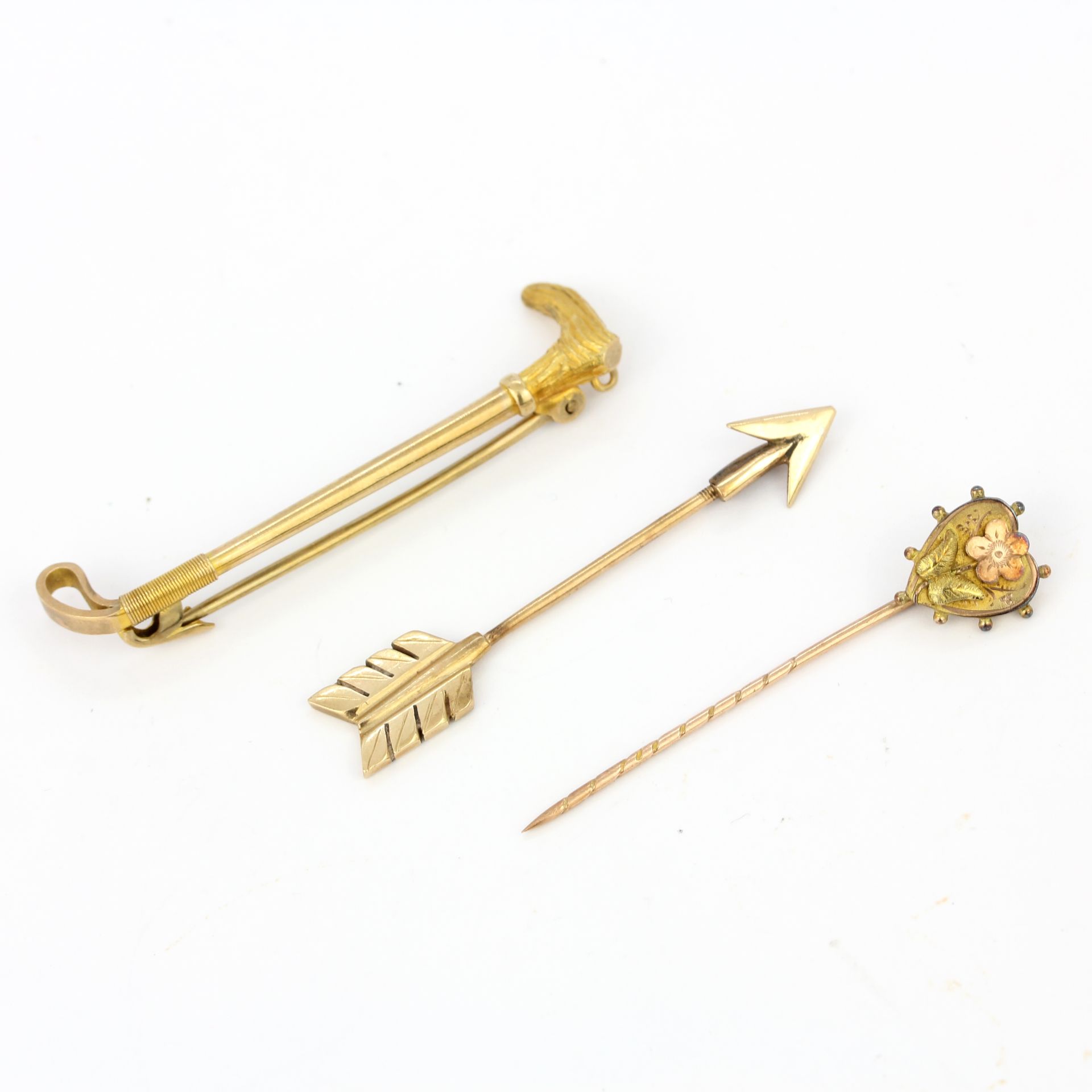A 9ct yellow gold brooch together with two 9ct gold tie pins, L. 4.5 and 4cm.