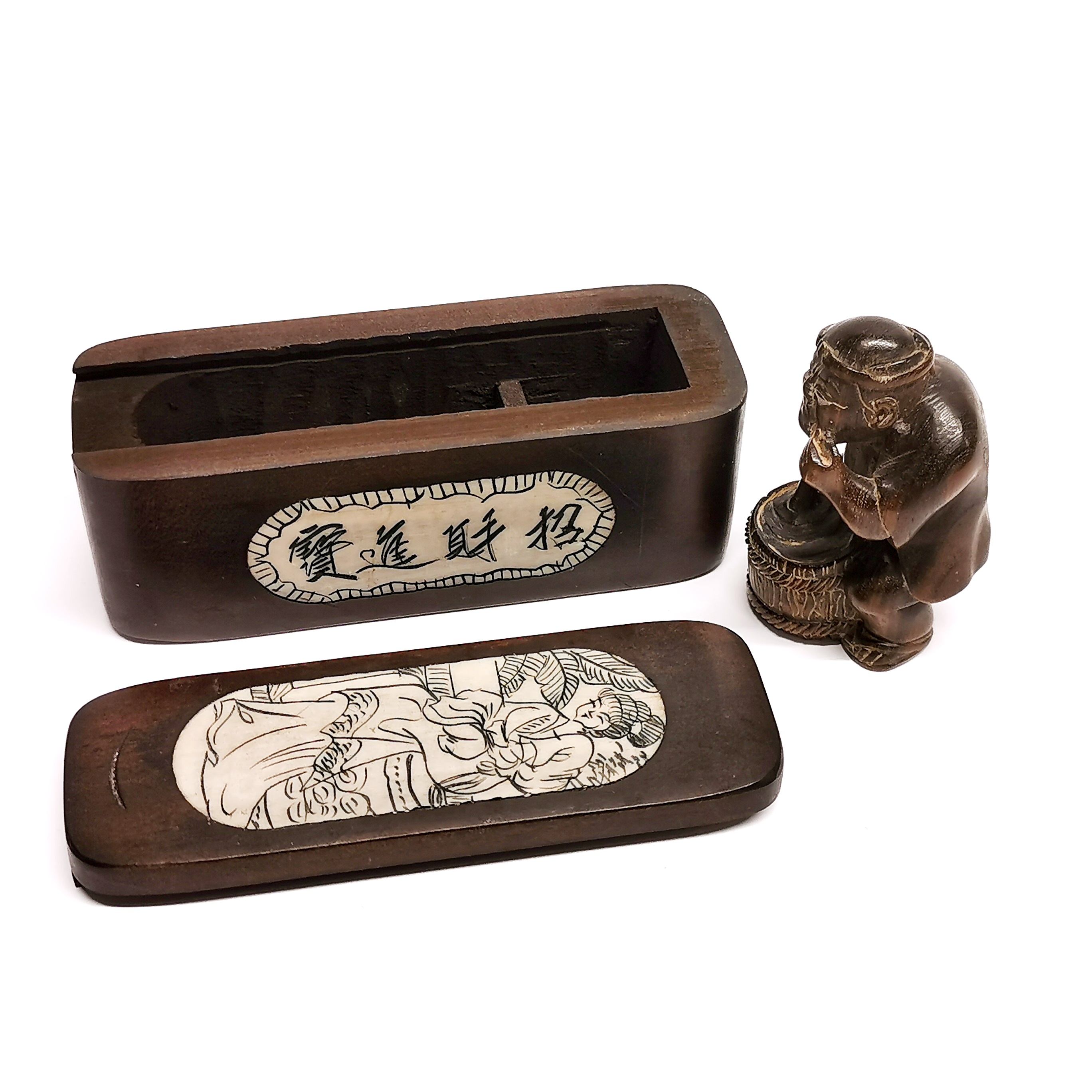 A carved signed fruitwood netsuke with an inlaid oriental box.