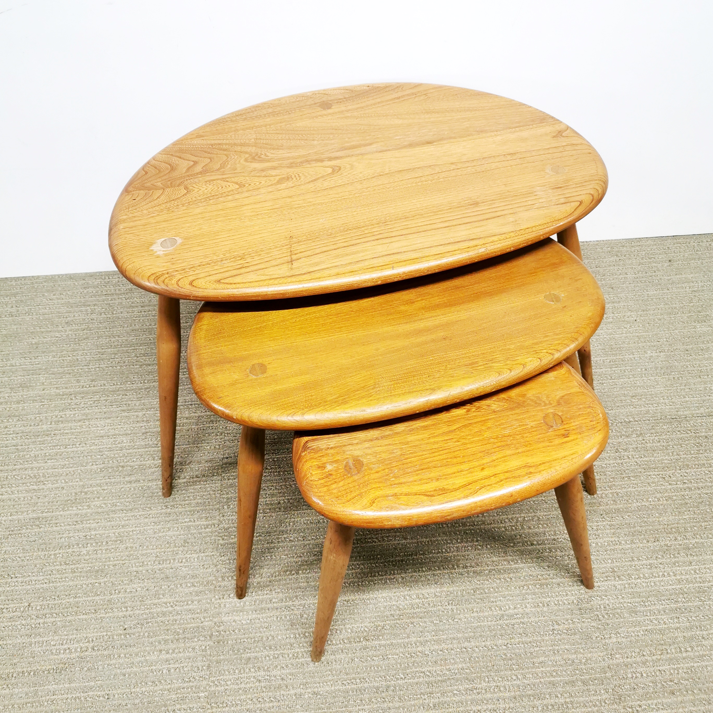 A nest of three Ercol pebble tables, largest W. 64cm.