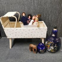 A doll's crib with a group of dolls and other items.