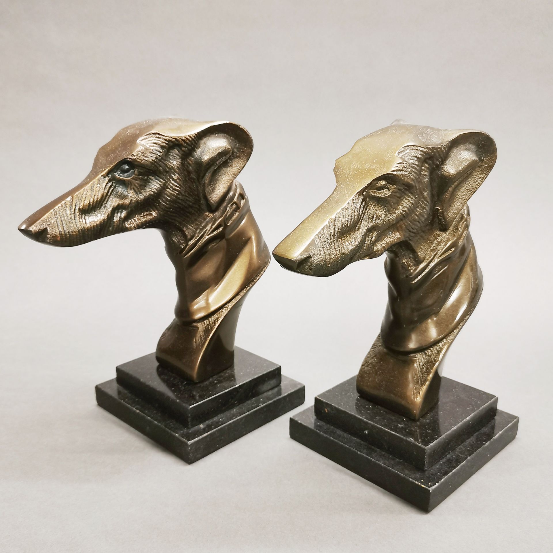 A pair of Art Deco style bronze and marble dog head bookends, H. 22cm.