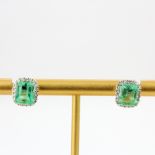 A pair of 18ct white gold earrings set with emerald cut emeralds and diamonds, L. 1.1cm.