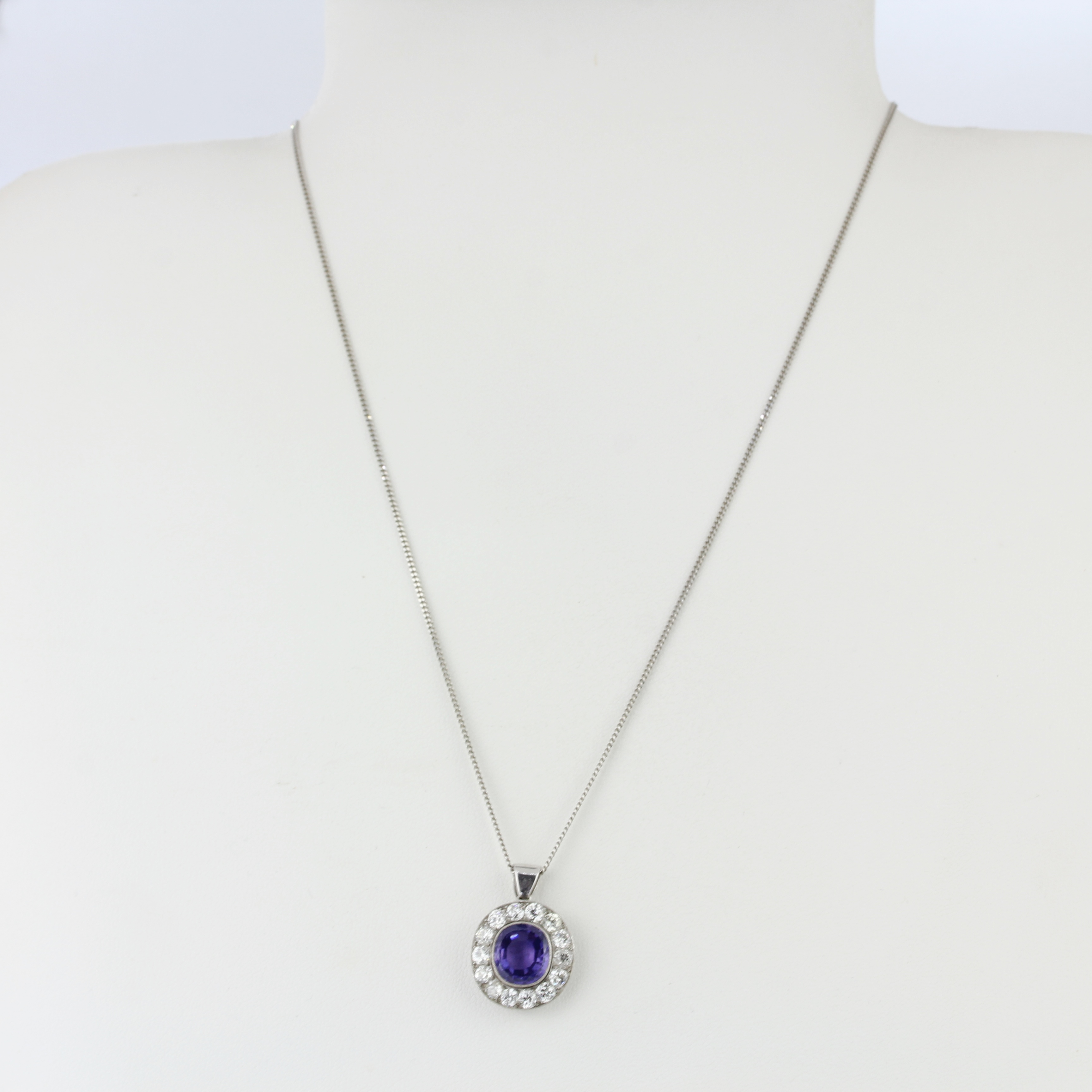 A white metal (tested minimum 9ct gold) pendant set with an oval cut purplish sapphire surrounded by - Bild 3 aus 4