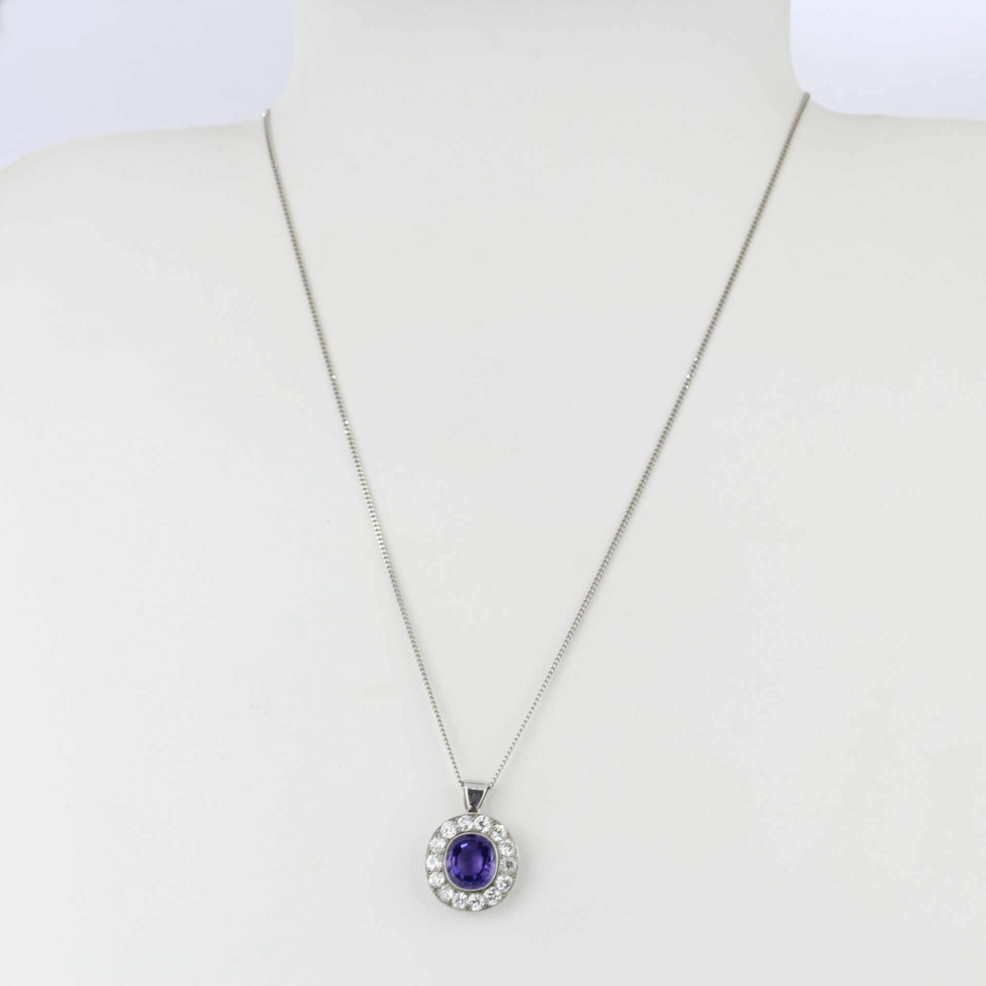 A white metal (tested minimum 9ct gold) pendant set with an oval cut purplish sapphire surrounded by - Image 3 of 4