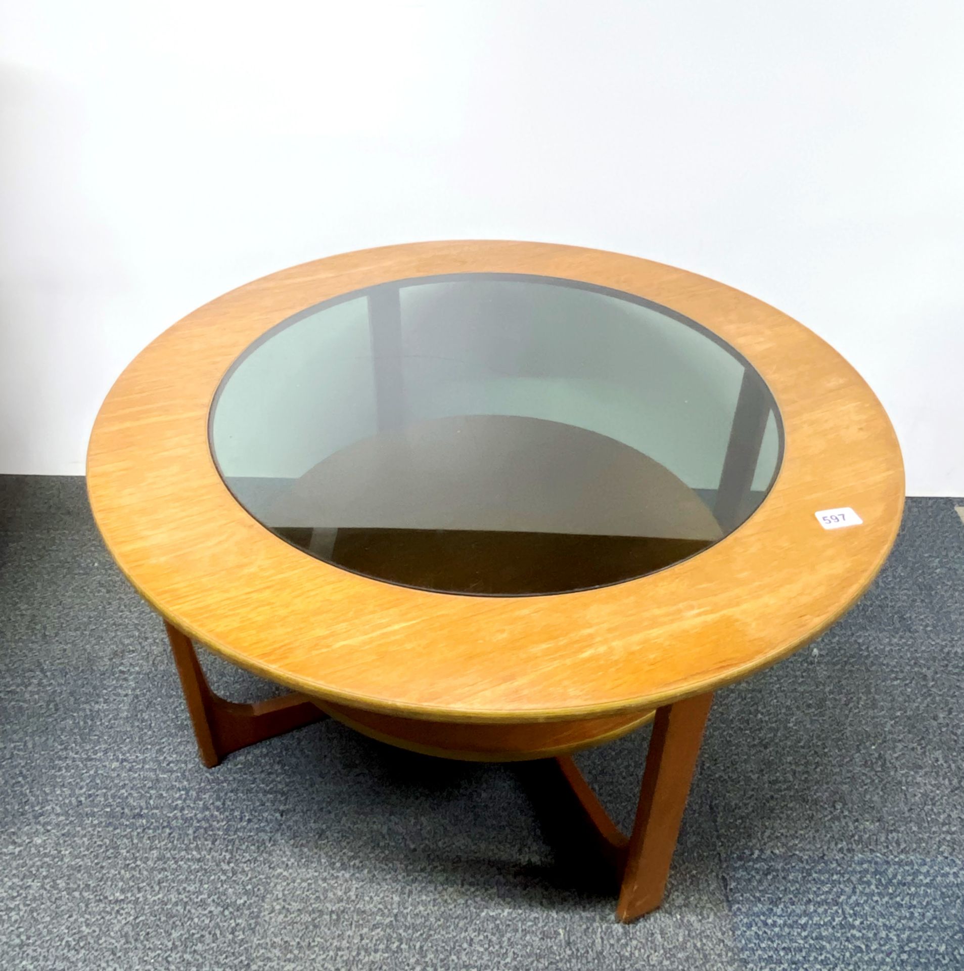 A Remploy circular teak and smoked glass coffee table, dia. 84cm.