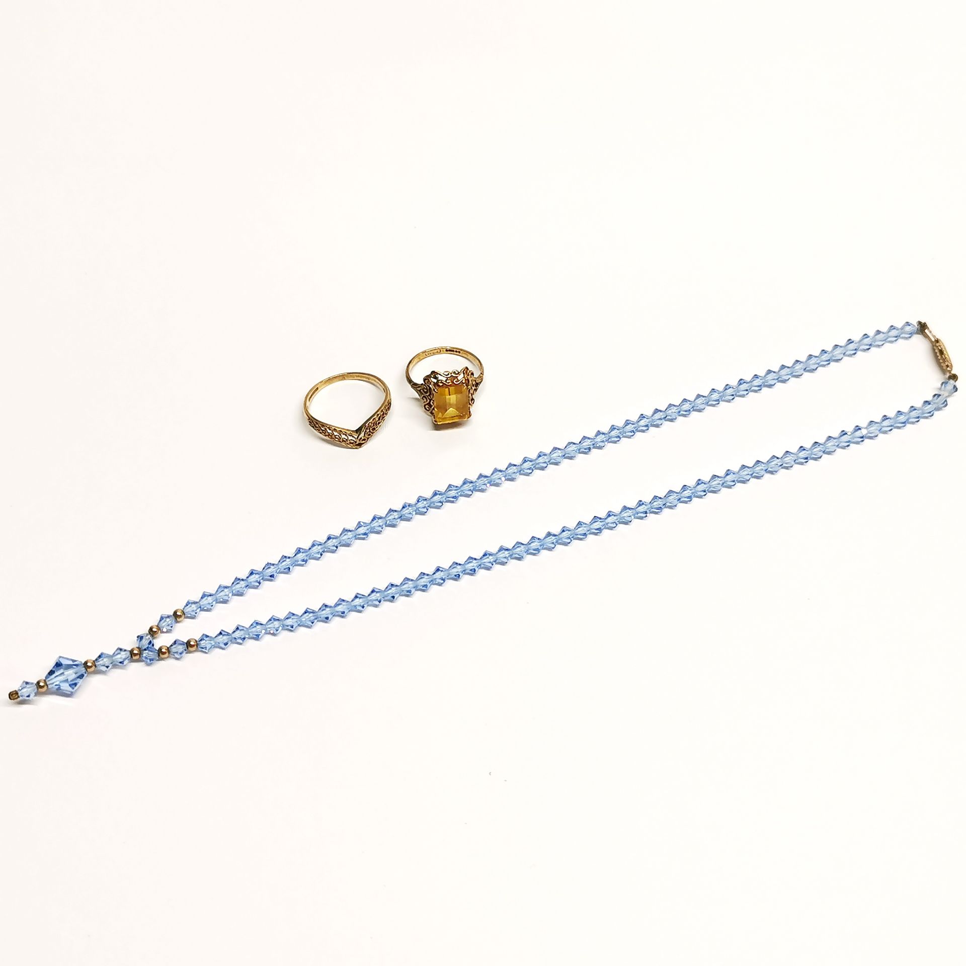 Two small 9ct gold rings and a 9ct gold crystal necklace.