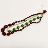 A graduated faux cherry amber necklace with a green bakelite necklace.