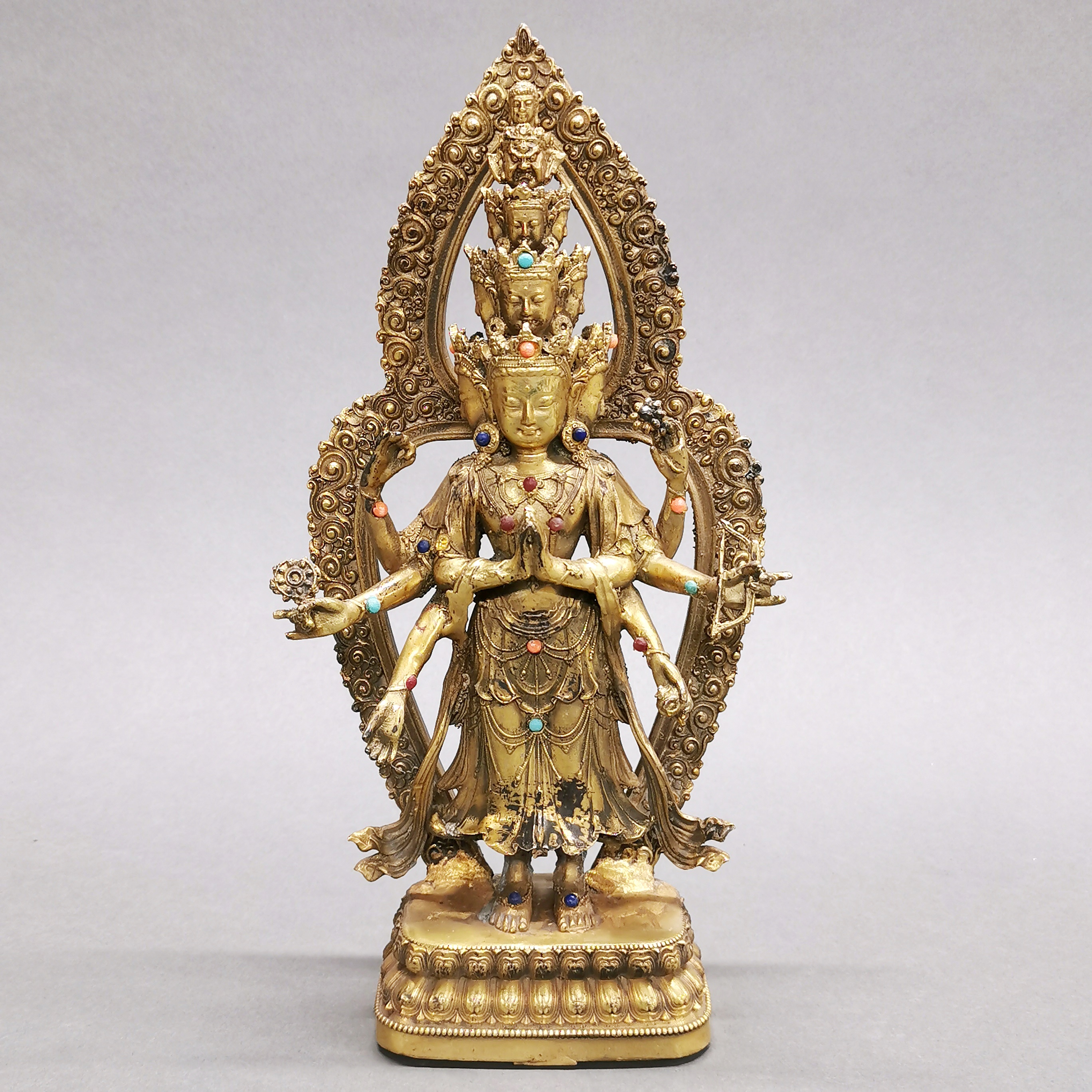 A Tibetan jewelled gilt bronze figure of a multi-armed deity, H. 28cm.