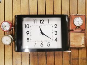 A vintage leather folding travel clock with two small alarm clocks and a battery operated wall