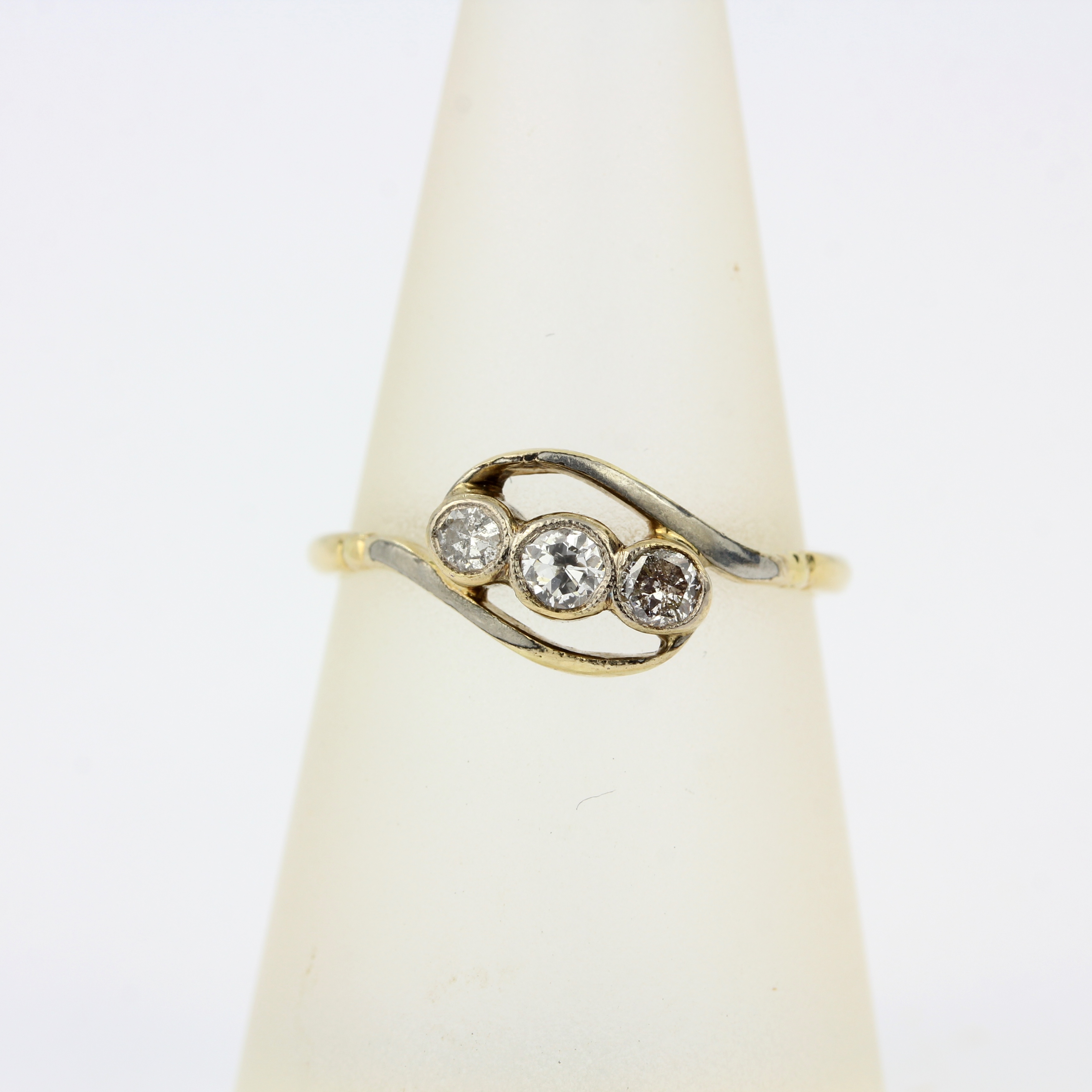 An early 20th century 18ct and platinum crossover ring set with three brilliant cut diamonds, ring