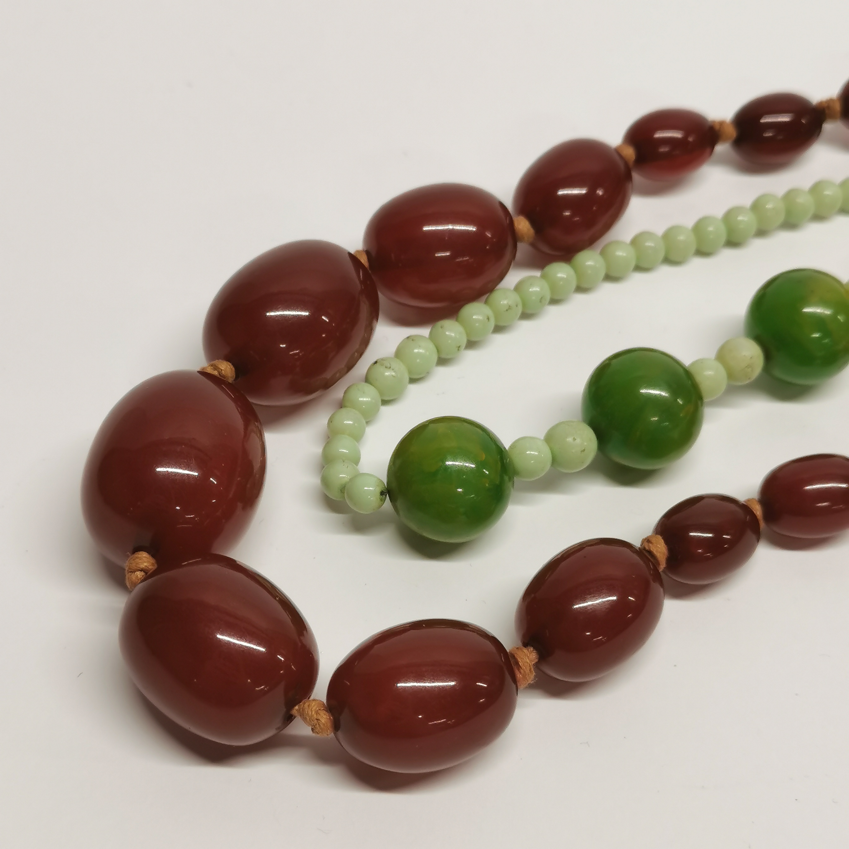 A graduated faux cherry amber necklace with a green bakelite necklace. - Image 2 of 3