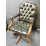 A leather upholstered mahogany swivel chair.