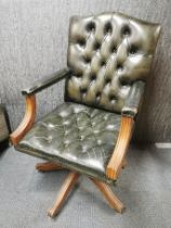 A leather upholstered mahogany swivel chair.