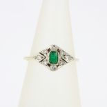 An Art Deco 18ct gold and platinum (worn hallmarks) ring set with diamonds and an emerald cut