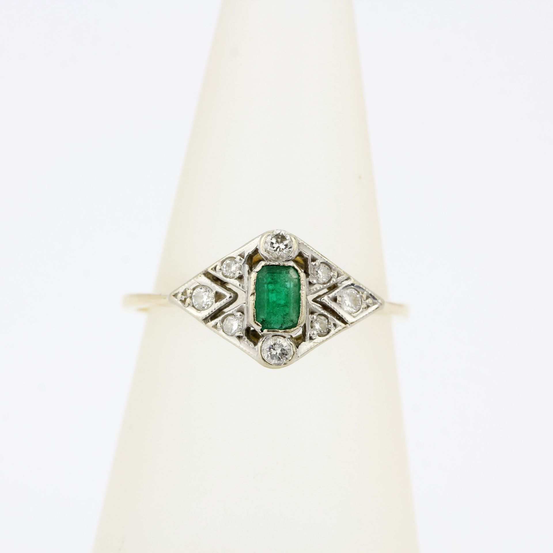 An Art Deco 18ct gold and platinum (worn hallmarks) ring set with diamonds and an emerald cut