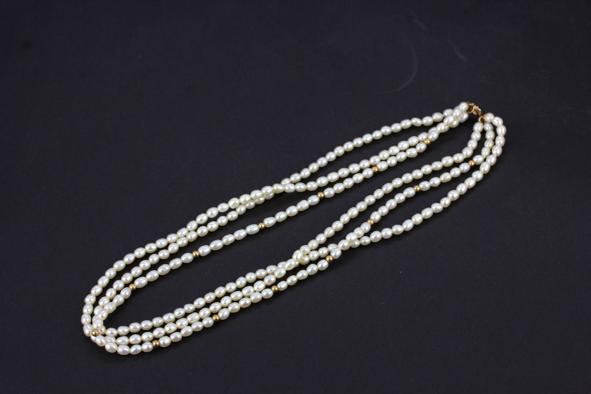 A 9ct yellow gold three row necklace, L. 40cm.