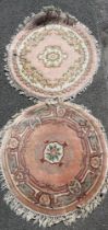 A pink ground washed wool Chinese rug together with a similar wool rug, largest dia. 125cm.