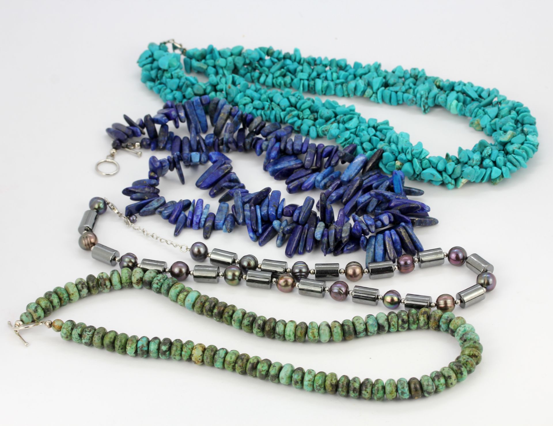 Four bead necklaces : turquoise, lapis lazuli, hematite and nephrite.