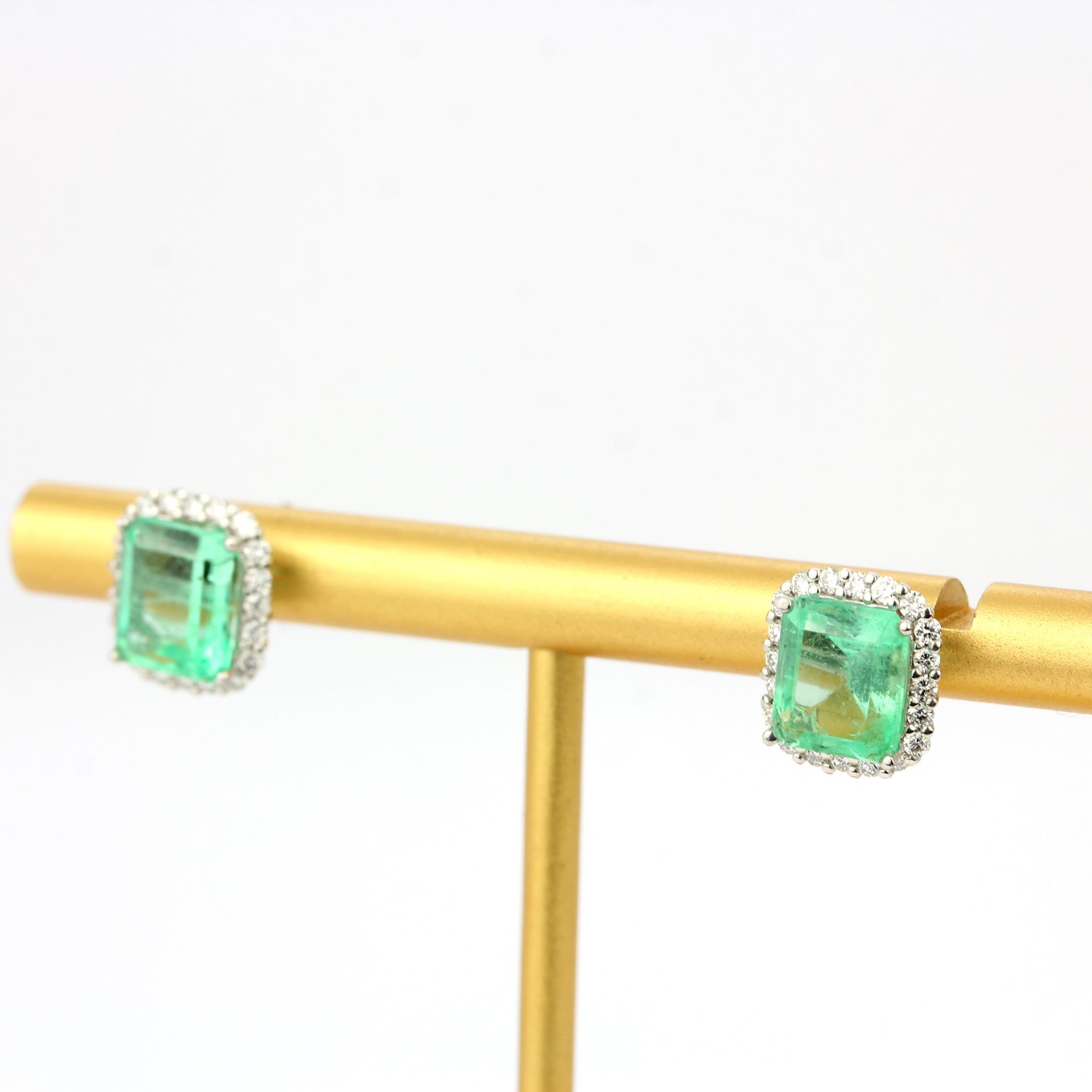 A pair of 18ct white gold earrings set with emerald cut emeralds and diamonds, L. 1.1cm. - Image 2 of 3