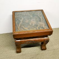 A heavy Eastern carved teak side table with inset glass top, 47 x 47 x 44cm.