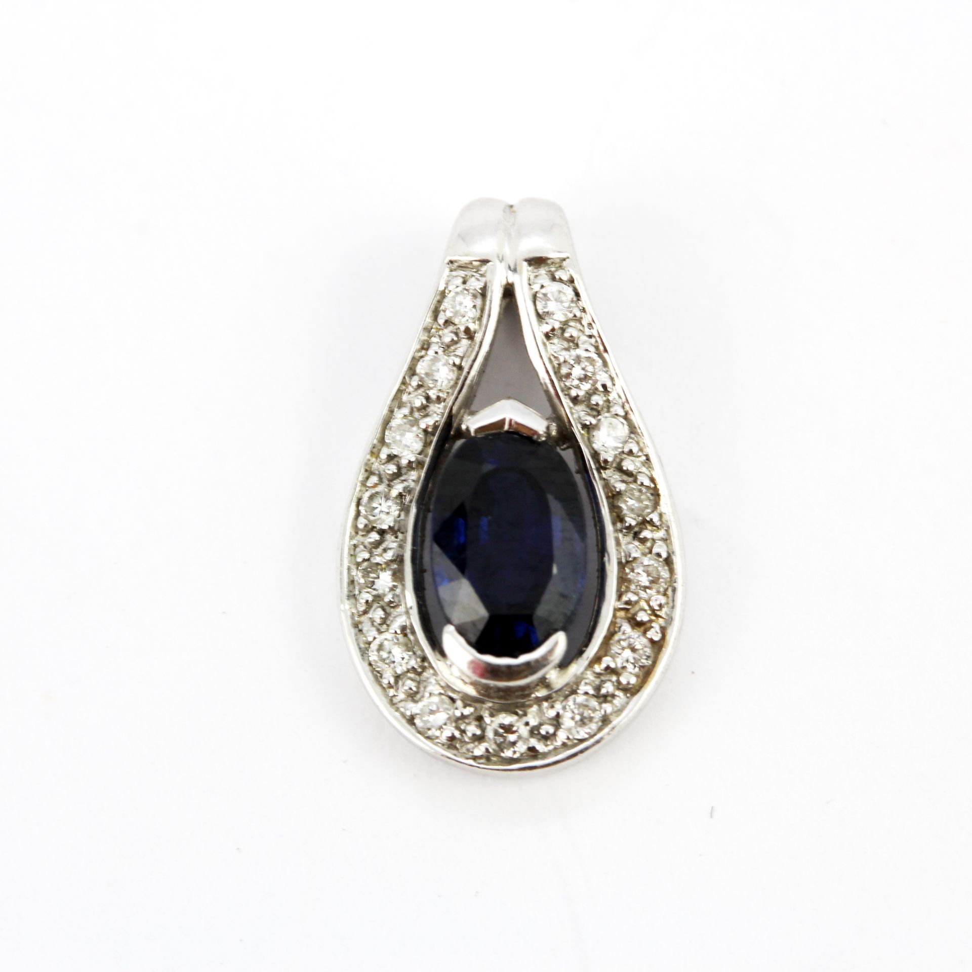 An 18ct white gold pendant set with an oval cut sapphire surrounded by diamonds, L. 1.5cm.