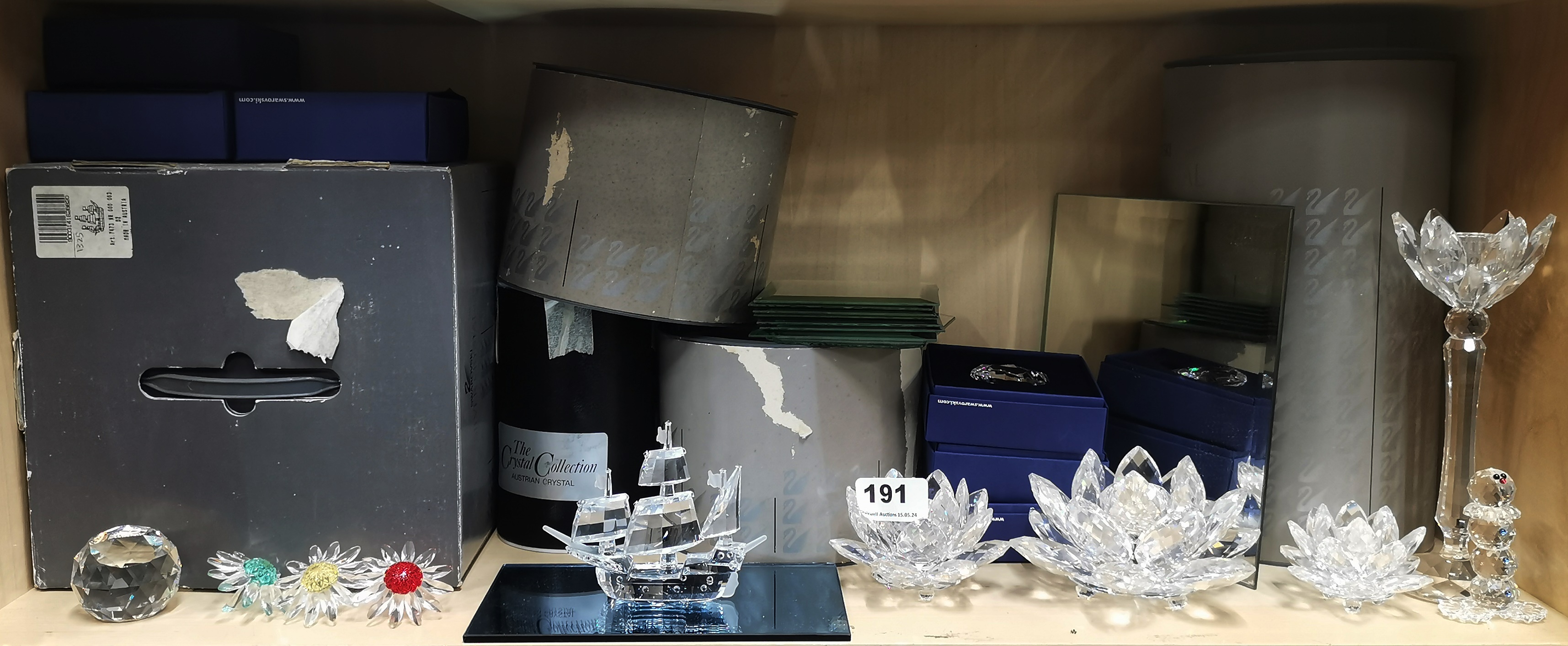 A group of boxed Swarovski crystal items including candle holders and a Santa Maria Galleon,