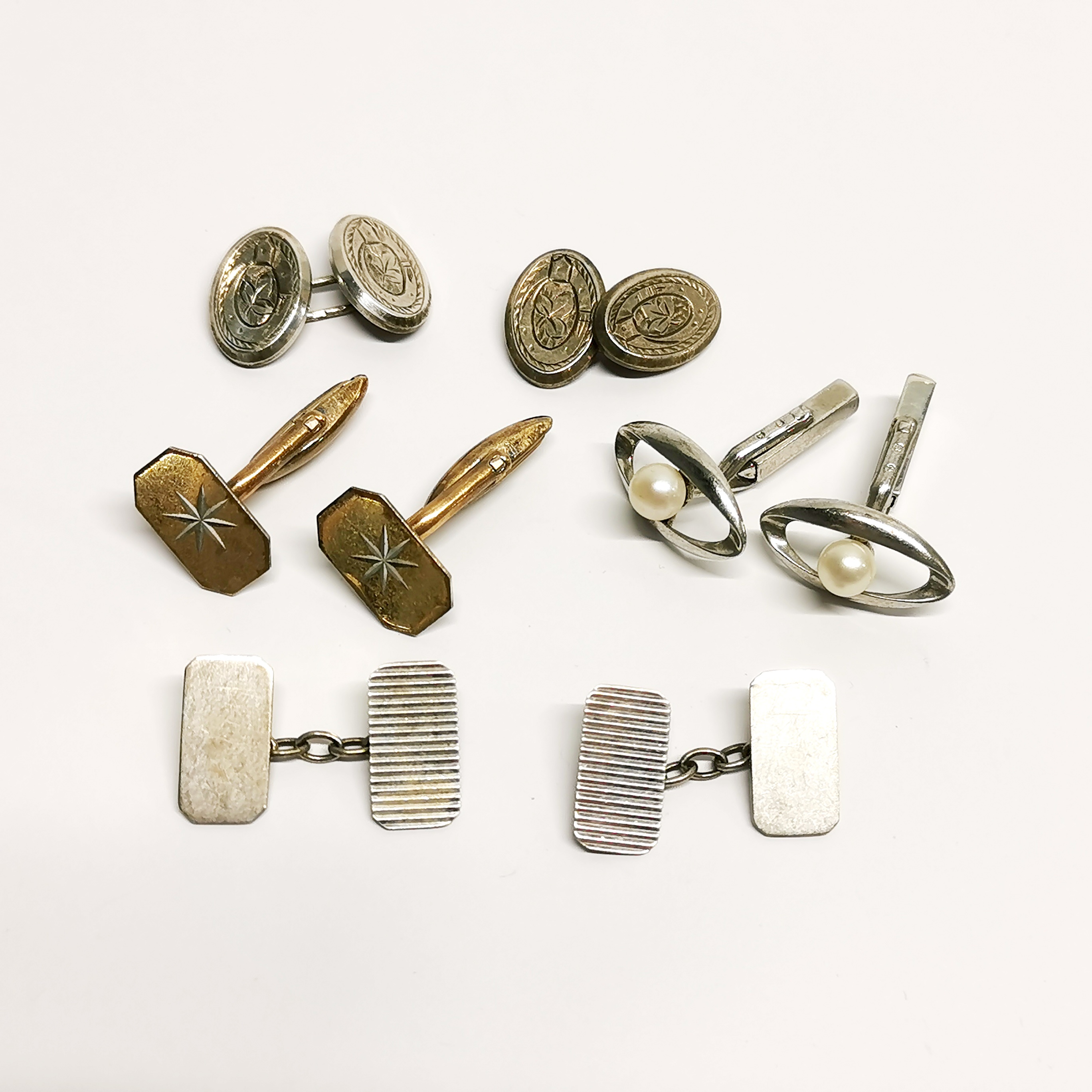A group of vintage silver cufflinks.