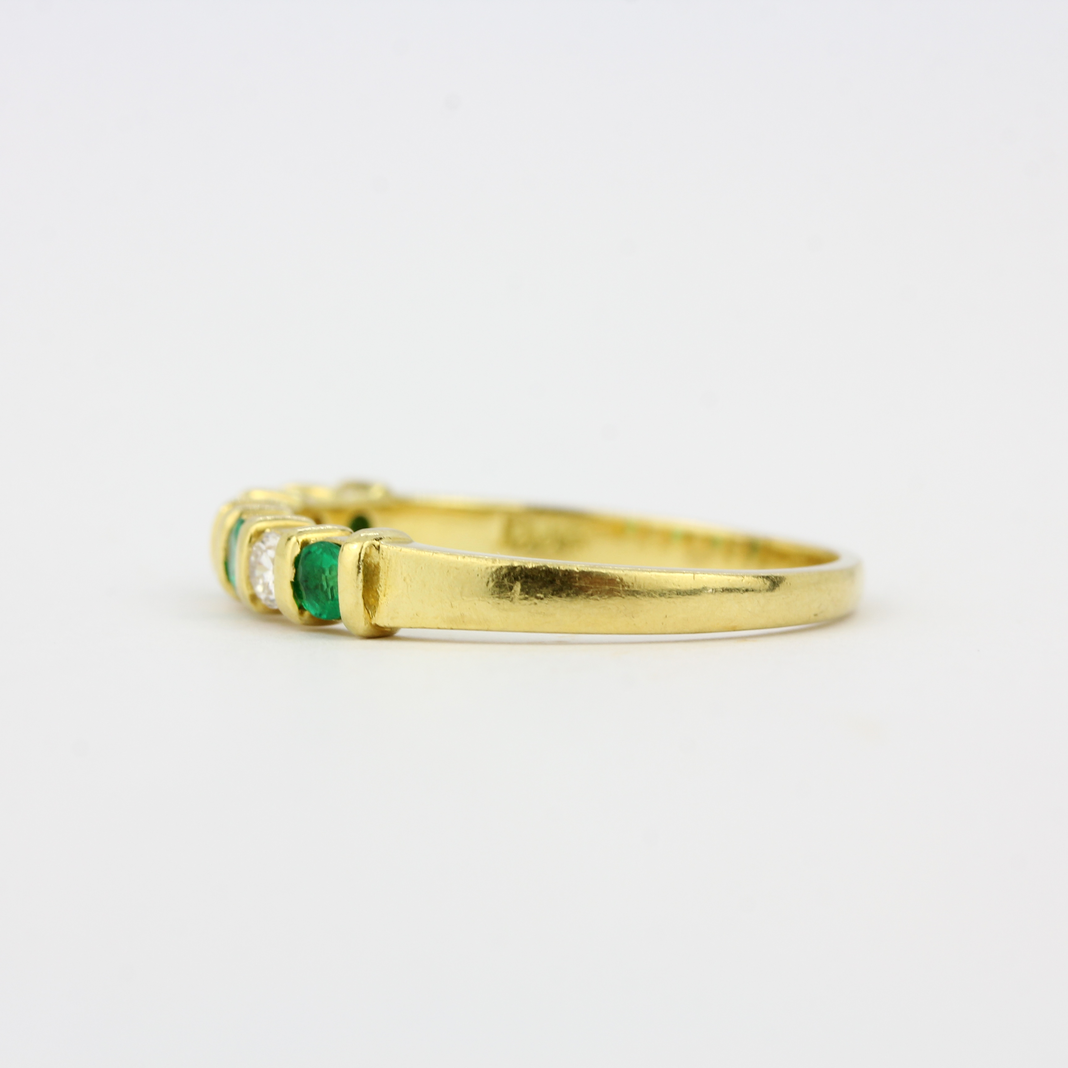 An 18ct yellow gold half eternity ring set with brilliant cut diamonds and emeralds, (O.5). - Image 3 of 3