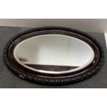 A 1920's oval framed mirror, W. 83cm.